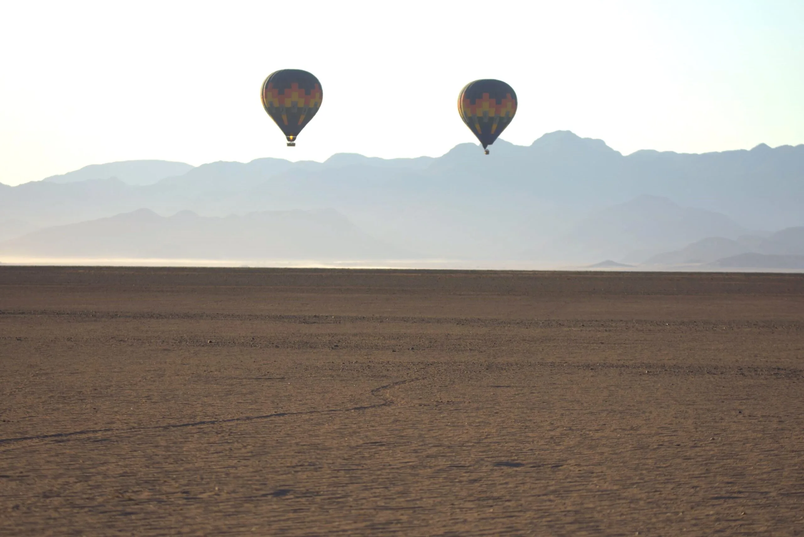 A colourful hot air balloon chasing the sunrise over the Namibian savannah